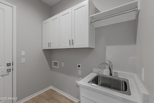 washroom with cabinets, sink, washer hookup, hookup for an electric dryer, and light hardwood / wood-style floors