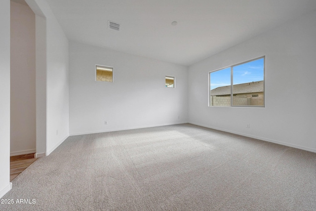 carpeted empty room featuring visible vents and baseboards