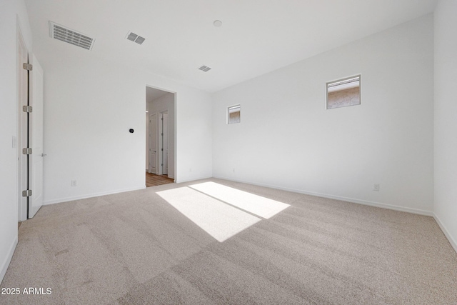 carpeted empty room with visible vents and baseboards