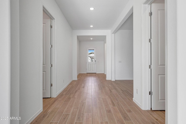 hallway featuring recessed lighting, light wood-style flooring, and baseboards