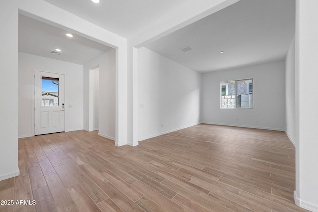 empty room featuring visible vents, light wood-style flooring, recessed lighting, and baseboards