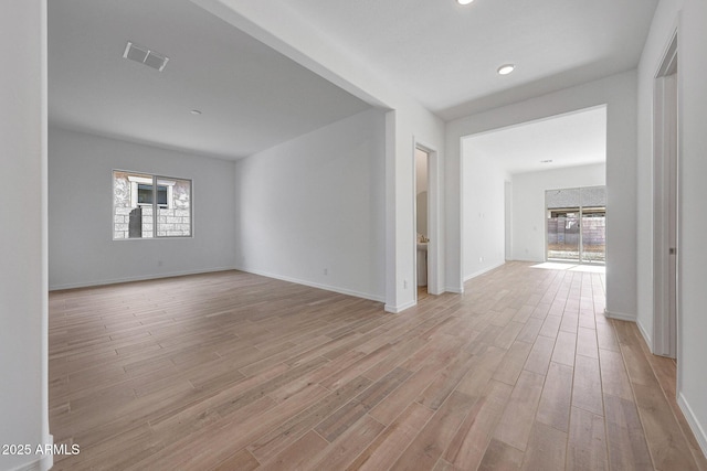 unfurnished room featuring visible vents, baseboards, and light wood-style flooring