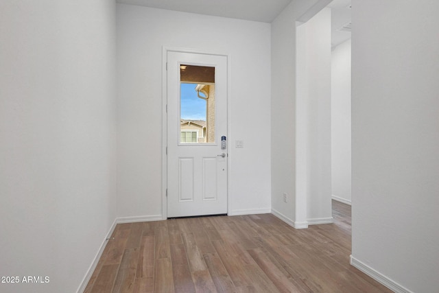 foyer featuring baseboards and wood finished floors