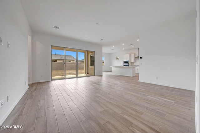 unfurnished living room with light wood-style flooring, recessed lighting, baseboards, and visible vents