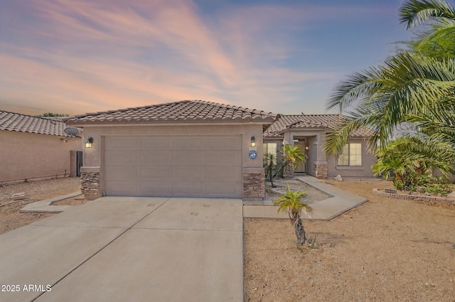 10305 E Dragoon Ave, Mesa, AZ 85208 - mediterranean / spanish house with driveway, an attached garage, stucco siding, a tiled roof, and stone siding
