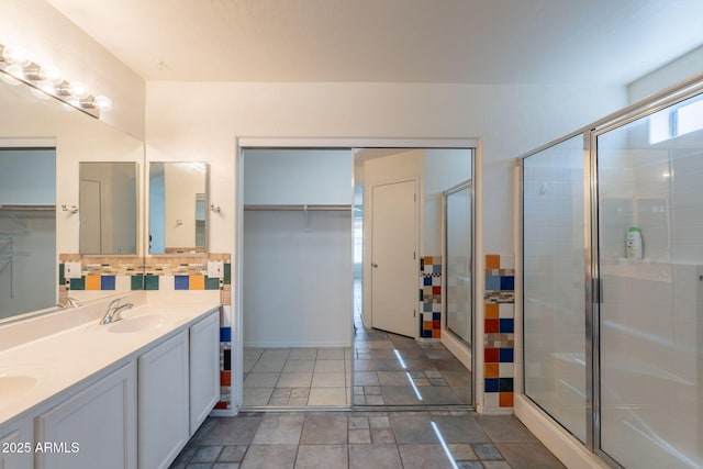 10305 E Dragoon Ave, Mesa, AZ 85208 - full bathroom featuring decorative backsplash, double vanity, a spacious closet, a stall shower, and stone finish flooring