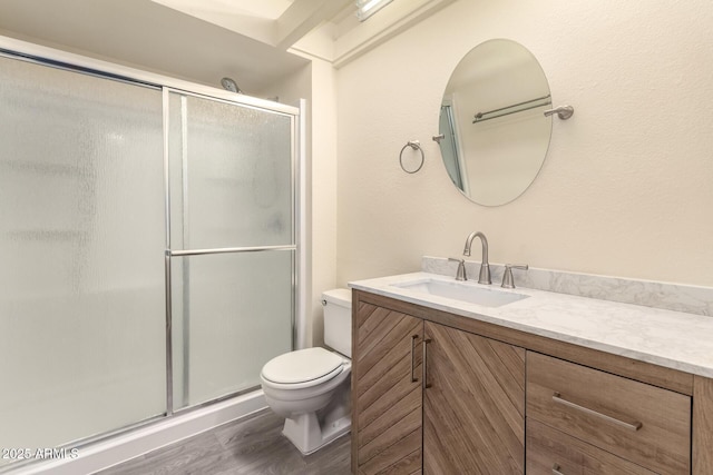 bathroom featuring vanity, an enclosed shower, wood-type flooring, and toilet