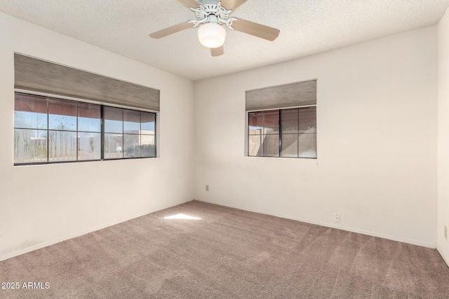 carpeted spare room featuring ceiling fan and a textured ceiling