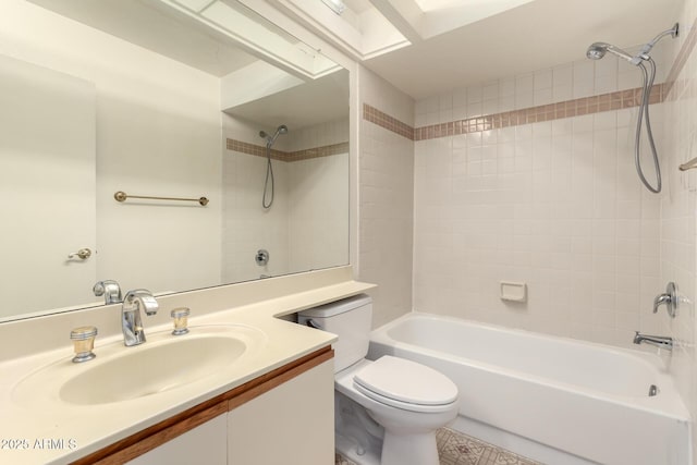 full bathroom featuring tiled shower / bath, vanity, and toilet