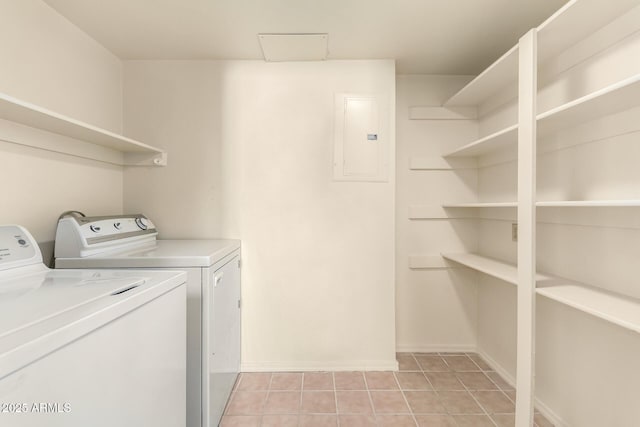 laundry room with electric panel, washer and dryer, and light tile patterned flooring