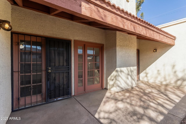 view of exterior entry featuring a patio area