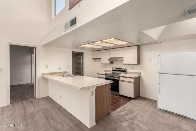 kitchen featuring sink, white refrigerator, kitchen peninsula, carpet floors, and electric stove