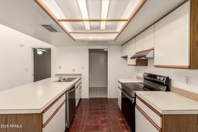 kitchen featuring sink, appliances with stainless steel finishes, white cabinets, dark tile patterned flooring, and kitchen peninsula