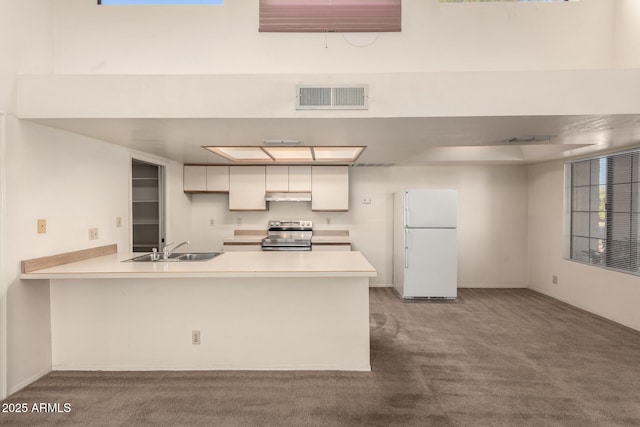 kitchen featuring sink, white cabinetry, white refrigerator, stainless steel electric stove, and kitchen peninsula