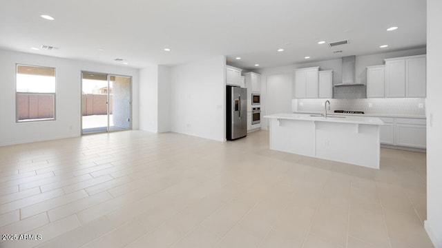 25118 N 171st Ln, Surprise, AZ 85387 - kitchen featuring stainless steel appliances, wall chimney exhaust hood, open floor plan, tasteful backsplash, and light countertops