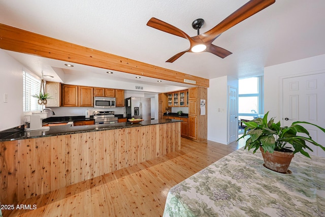 37414 N 17th Ave, Phoenix, AZ 85086 - kitchen with stainless steel appliances, a peninsula, brown cabinetry, a sink, and light wood-style floors