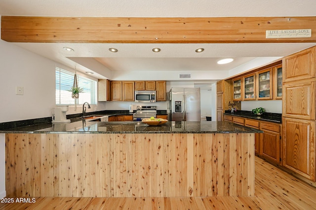 37414 N 17th Ave, Phoenix, AZ 85086 - kitchen featuring appliances with stainless steel finishes, light wood finished floors, a peninsula, brown cabinets, and dark stone counters