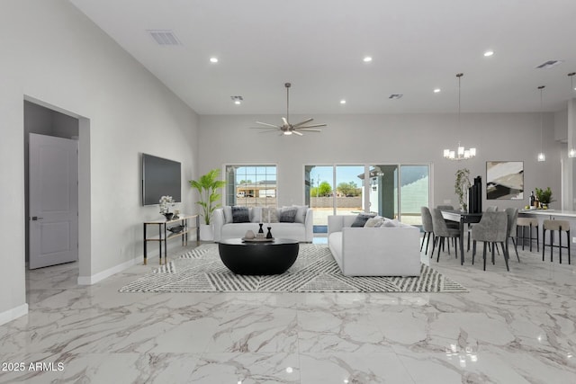 living room featuring visible vents, recessed lighting, a high ceiling, and ceiling fan with notable chandelier