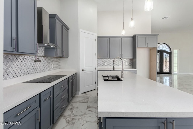kitchen with black electric stovetop, marble finish floor, wall chimney exhaust hood, and gray cabinetry
