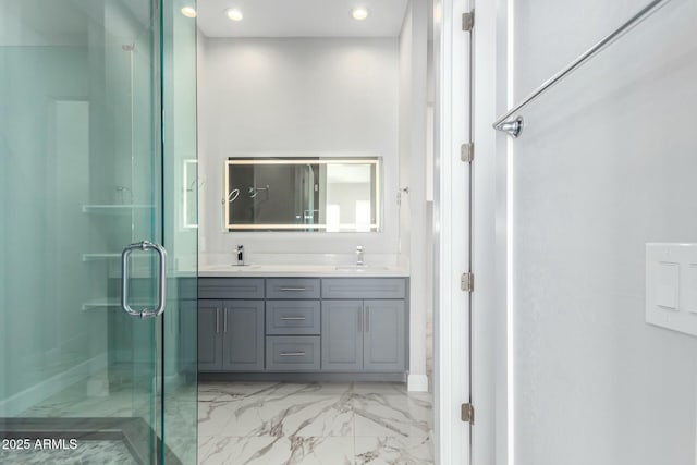 full bath featuring a shower stall, recessed lighting, marble finish floor, a sink, and double vanity
