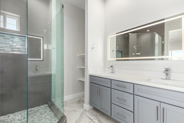 bathroom with a shower stall, double vanity, marble finish floor, and a sink