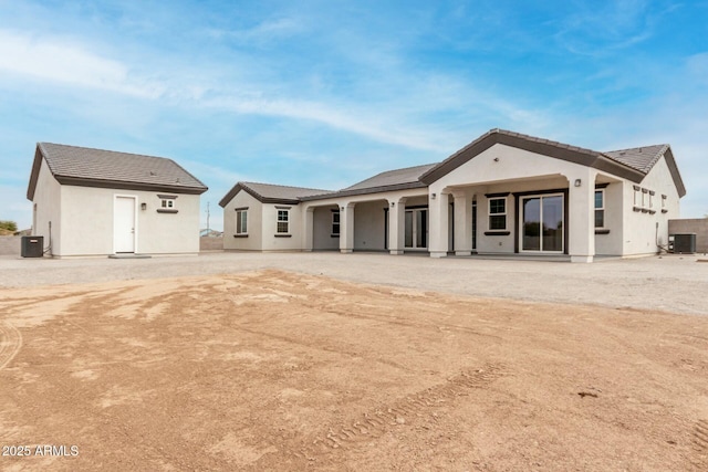 rear view of house featuring central AC, stucco siding, and a tile roof