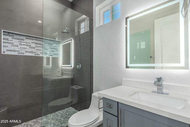 bathroom featuring toilet, a walk in shower, and vanity
