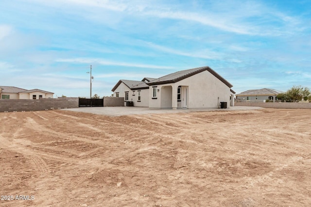 exterior space featuring stucco siding, a tiled roof, and fence