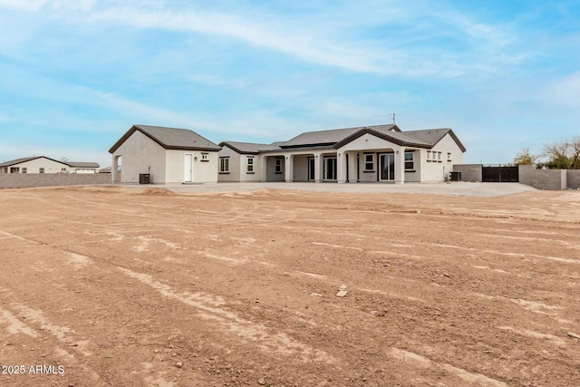 back of house with stucco siding and fence