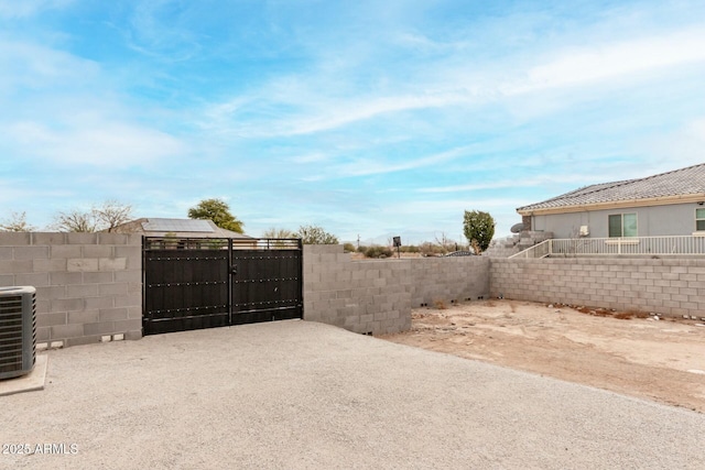 view of gate featuring central air condition unit and fence private yard