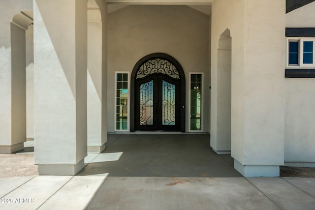 entrance to property with french doors and stucco siding