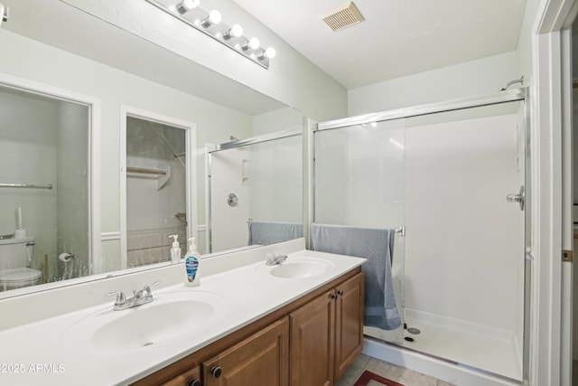 2401 E Antigua Dr, Casa Grande, AZ 85194 - full bathroom featuring a shower stall, double vanity, tile patterned flooring, and toilet