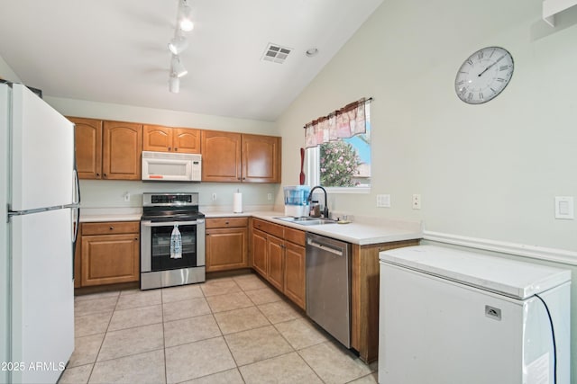 2401 E Antigua Dr, Casa Grande, AZ 85194 - kitchen featuring appliances with stainless steel finishes, a sink, light countertops, light tile patterned floors, and brown cabinetry