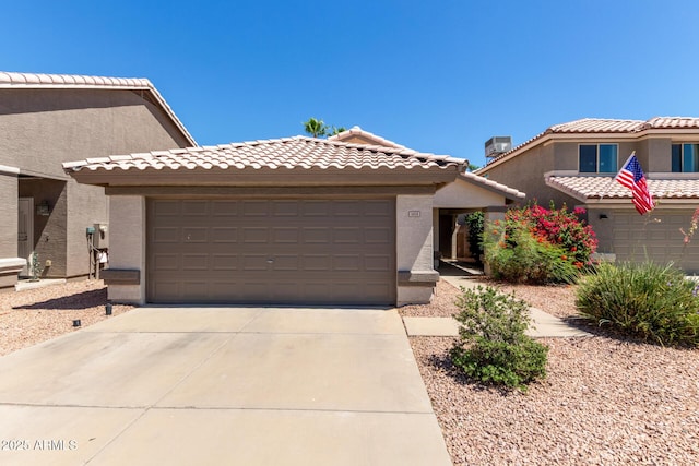 5018 W Wikieup Ln, Glendale, AZ 85308 - view of front of house featuring concrete driveway, a garage, stucco siding, and a tiled roof