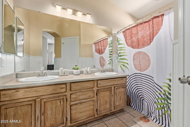 5018 W Wikieup Ln, Glendale, AZ 85308 - full bath with tile patterned flooring, double vanity, a wainscoted wall, and curtained shower