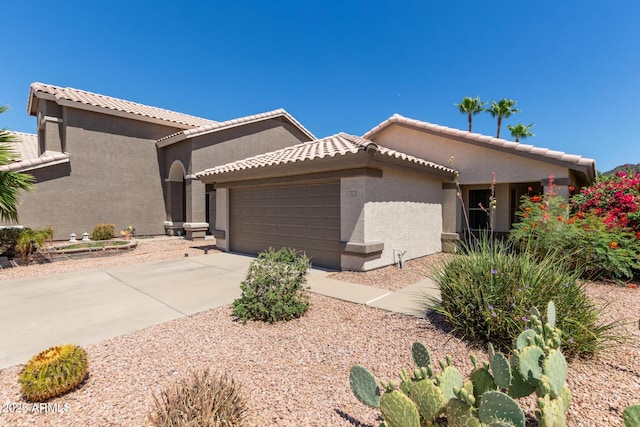 5018 W Wikieup Ln, Glendale, AZ 85308 - view of front of house with an attached garage, driveway, stucco siding, and a tile roof