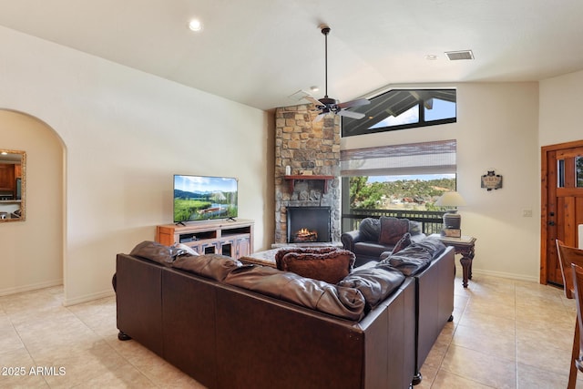 living room featuring arched walkways, visible vents, ceiling fan, vaulted ceiling, and a fireplace