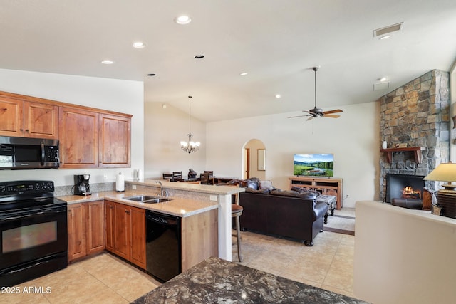 kitchen with a peninsula, a sink, open floor plan, black appliances, and brown cabinetry