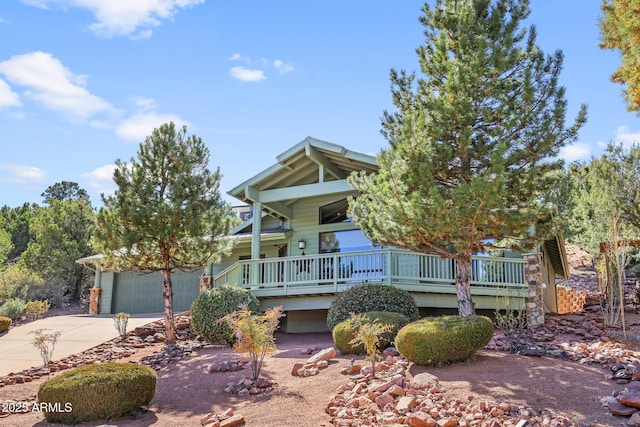 view of front of home with concrete driveway and a wooden deck