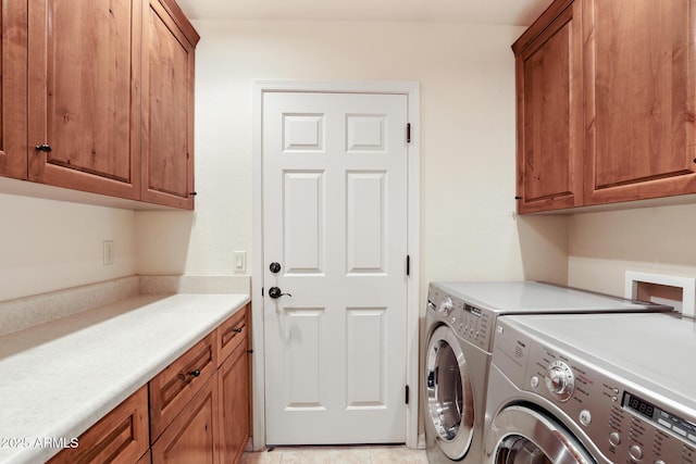 washroom with cabinet space and washer and clothes dryer