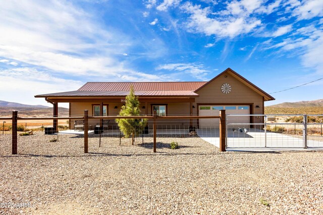 16147 W Apache Way, Peeples Valley, AZ 86332 - view of front of property with a mountain view, metal roof, a garage, an outdoor structure, and concrete driveway