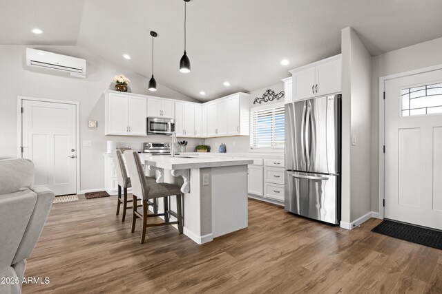 16147 W Apache Way, Peeples Valley, AZ 86332 - kitchen featuring appliances with stainless steel finishes, a wall mounted air conditioner, lofted ceiling, and a wealth of natural light