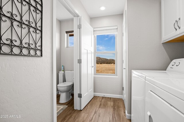 16147 W Apache Way, Peeples Valley, AZ 86332 - laundry room featuring independent washer and dryer, light wood-style floors, baseboards, and cabinet space