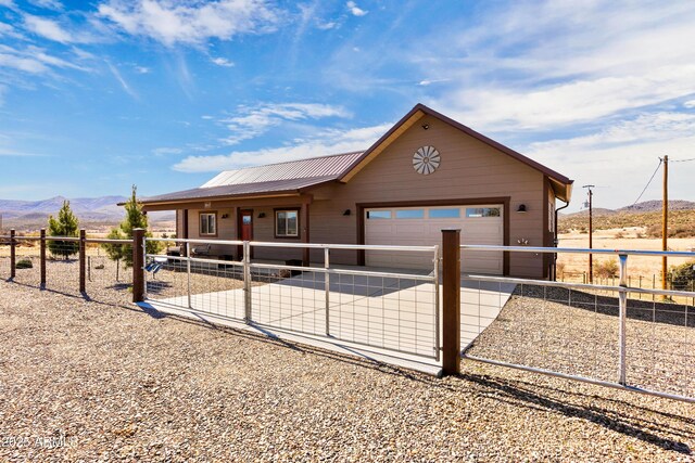 16147 W Apache Way, Peeples Valley, AZ 86332 - view of front of property with a mountain view, metal roof, a garage, and concrete driveway