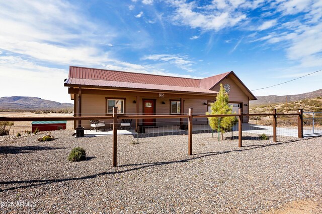 16147 W Apache Way, Peeples Valley, AZ 86332 - view of front of house featuring a mountain view, an attached garage, fence, and metal roof