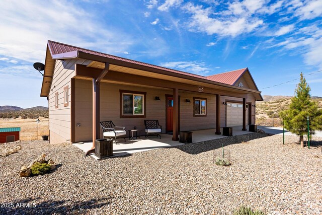 16147 W Apache Way, Peeples Valley, AZ 86332 - view of front facade featuring a mountain view, a porch, metal roof, and a garage