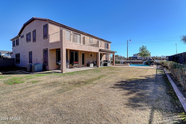 rear view of property with a patio, a lawn, a fenced in pool, and central air condition unit