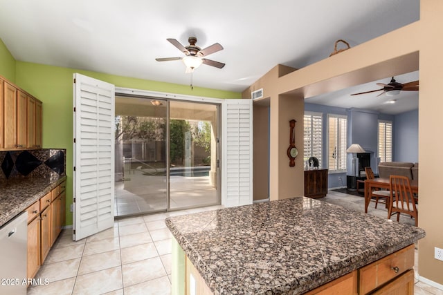 kitchen with light tile patterned floors, ceiling fan, baseboards, and dishwasher