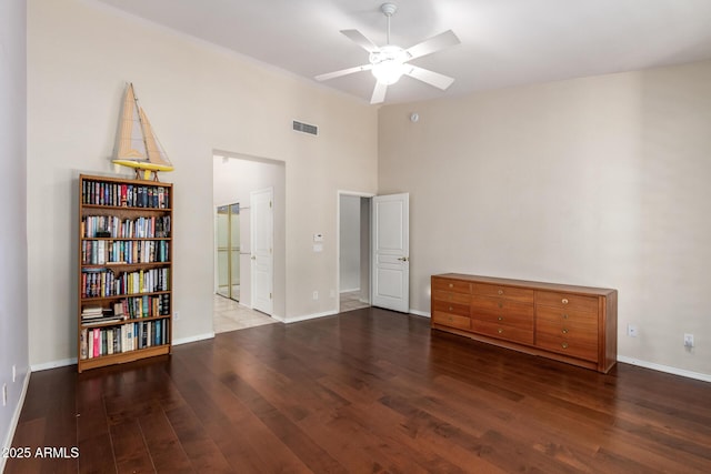 interior space featuring ceiling fan, wood finished floors, visible vents, and baseboards