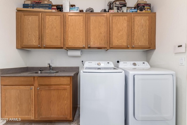 clothes washing area with washing machine and dryer, cabinet space, and a sink